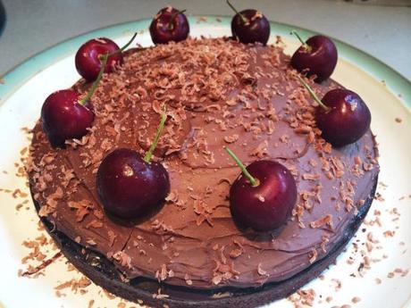black forest cake chocolate topping with fresh cherries and stalks and grated chocolate
