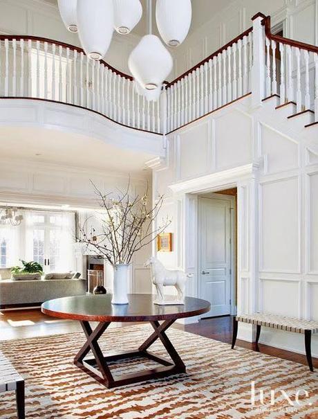 luxe two story foyer white wainscoting wall paneling