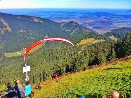 Paraglider taking off from Laber Mountain to sail over the Ammergau Alps.