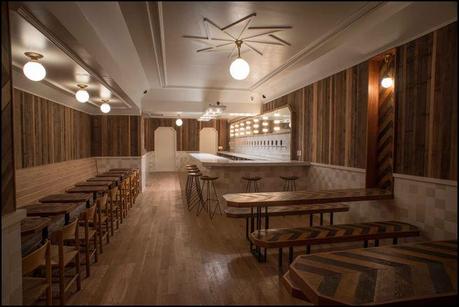Torst bar with wooden tables and wall paneling and marble bar