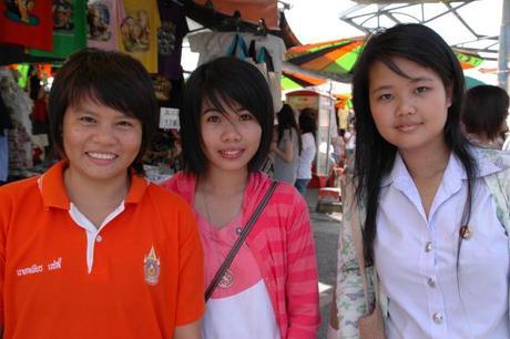 Three young students practice their English skills by interviewing foreigners. Photo Briar Jensen.