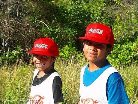 Two Nauruan girls sport a Coca-cola cap during a fun walk
