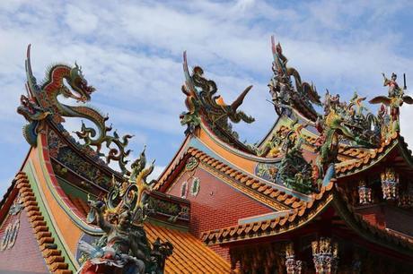 Dragons coloured scarlet, green and blue adorn three pointed temple roofs in Jiufen, Taiwan.