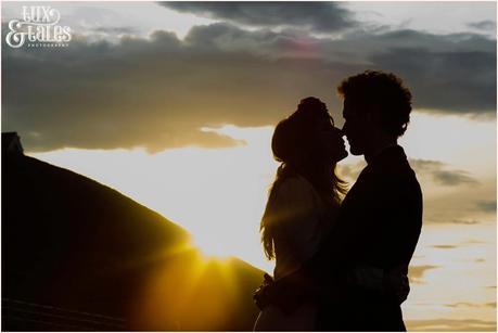 Photography Engagement Shoot in Whitby | Girl wearing Red Flower crown | Alterntive Couple whereing Vintage clothing | Silhouette in the sunset at the beach