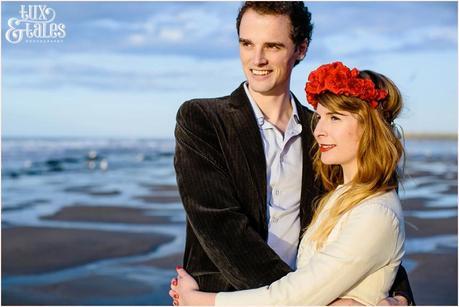 Photography Engagement Shoot in Whitby | Girl wearing Red Flower crown | Alterntive Couple whereing Vintage clothing | Hugging couple looking into sunset