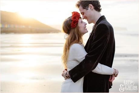 Photography Engagement Shoot in Whitby | Girl wearing Red Flower crown | Alterntive Couple whereing Vintage clothing | couple hugging in the sunset
