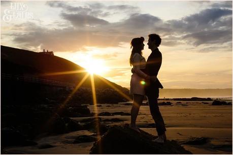 Photography Engagement Shoot in Whitby | Girl wearing Red Flower crown | Alterntive Couple whereing Vintage clothing | Beach silhouette with the sunset with starburst