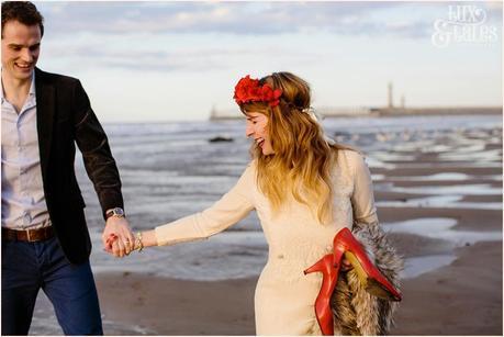 Photography Engagement Shoot in Whitby | Girl wearing Red Flower crown | Alterntive Couple whereing Vintage clothing | Holding hands on beach