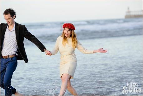 Photography Engagement Shoot in Whitby | Girl wearing Red Flower crown | Alterntive Couple whereing Vintage clothing | Being silly on the beach