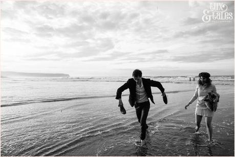 Photography Engagement Shoot in Whitby | Girl wearing Red Flower crown | Alterntive Couple whereing Vintage clothing | Running in the ocean man holding shoes