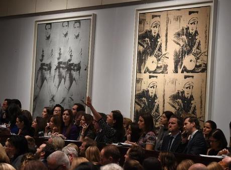 Andy Warhol's 'Triple Elvis' (left) and 'Four Marlons' are displayed during Christie's Post-War and Contemporary Art evening sale, in New York. They sold for a combined total of £96m
