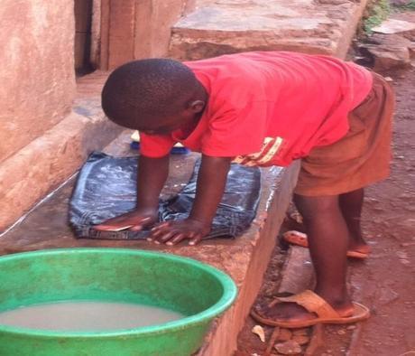 Angela Dempsey Aggie's Arts Uganda. child washing clothes