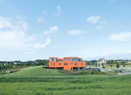 Seen here from the south, Villa van Vijven’s orange facade is meant to mimic the tiled rooftops of Holland’s country buildings, while the building’s horizontal pull echoes the flat landscape. The second-floor living rooms look out on the 4,200-square-foot