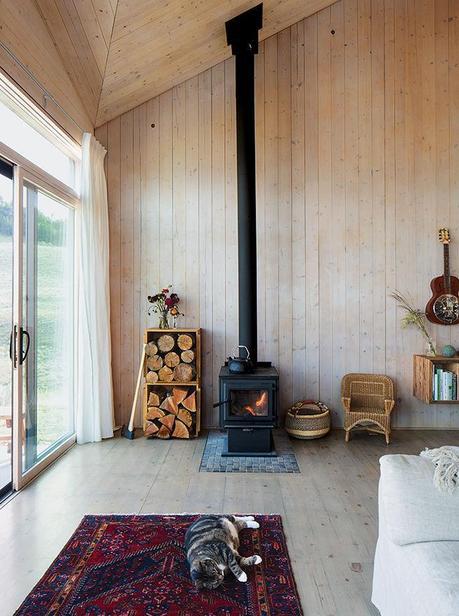 Modern prefab vacation home in Washington living room with true north stove and angular ceiling