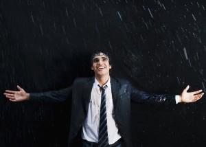 Happy businessman enjoying in the rain