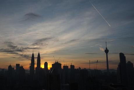 Petronas Towers lit up by the rising sun.