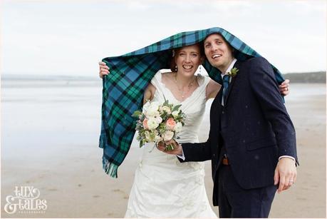 Bride & Groom Portraits in the rain at Newton Hall beachside wedding photography | Hiding under tartan shawl