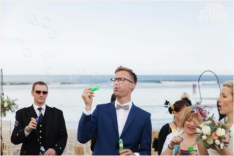 Ceremony Photography at Newton Hall beachside wedding | Guest Blowing Bubbles