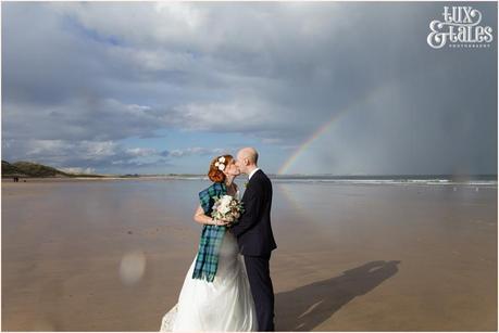 Bride & Groom Portraits in the rain at Newton Hall beachside wedding photography | Kissing under rainbow