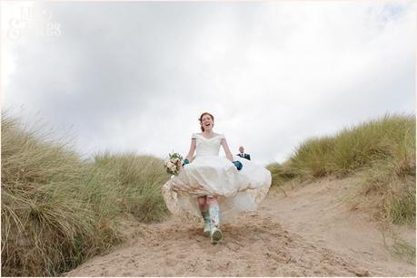 Bride & Groom Portraits in the rain at Newton Hall beachside wedding photography | Running down sand dune
