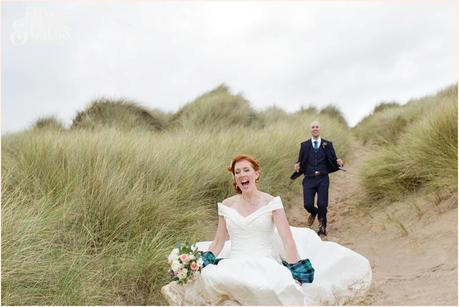 Bride & Groom Portraits in the rain at Newton Hall beachside wedding photography | Running down sand dune