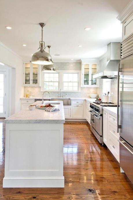 White Kitchen with a combination of cabinets with doors and a few glass front cabinets. gorgeous wood floor. white countertops