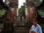 Simon on his phone with a temple behind