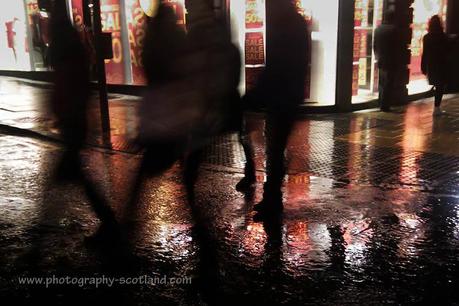 Photo - revellers hurry past the shops on Princes Street Edinburgh