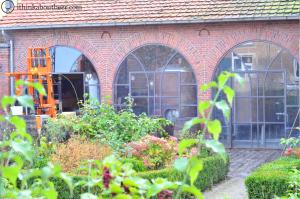 You can see the brewhouse and the kettles through the courtyard plants.