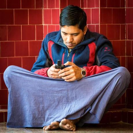 A Burmese man checks his mobile phone.(Photo: Flickr) 