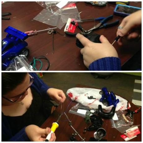 Using a screwdriver to open the remote to a toy car and soldering at DIYAbility.