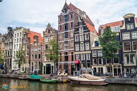 houses along a canal in Amsterdam with boats in the canal