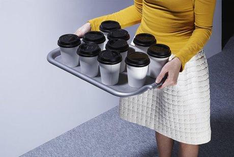 A woman carrying a tray of tea