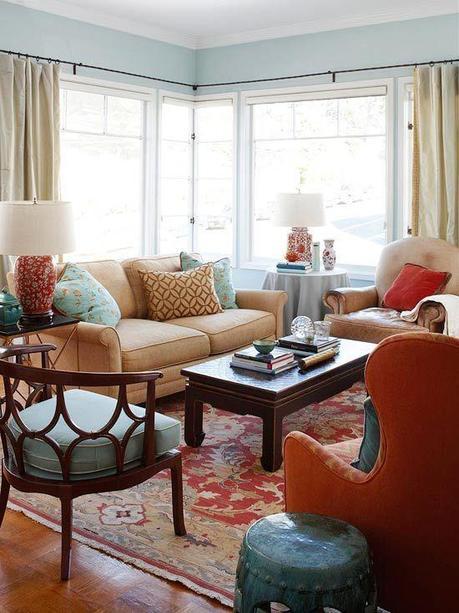 Living Room - The cool blues of this space are quickly warmed up by the bright reds. The corner window enlarges, the cozy cushions invite, and the unique accents lure you to explore their individuality. I am especially in love with the turquoise metal side table and the blue seat with star-shaped wooden back.