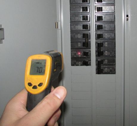 Infrared thermometer pointed at electric panel