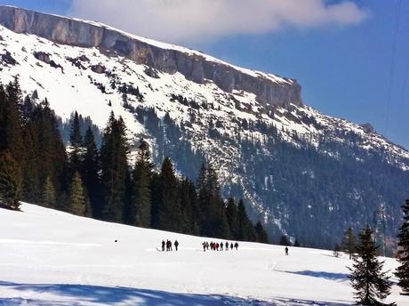 Winter hikers with mountains in the background in the Kleinwalsertal in Austria