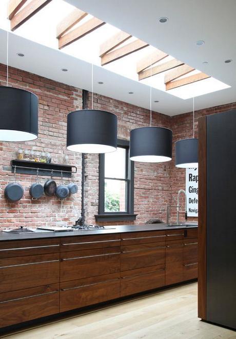 Industrial warehouse look kitchen with exposed red brick and sunlight with wooden beams. Love the hanging iron pans - adds so much character!