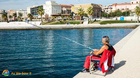 Civitavecchia fisherman sitting on concrete dock