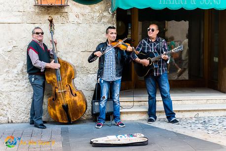 3 buskers on Corso Centocentelle, playing base, violin and guitar