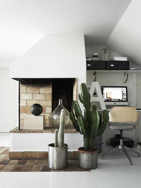 brick fireplace with cacti and desk