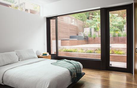 San Francisco master bedroom with a glass wall and a clerestory window
