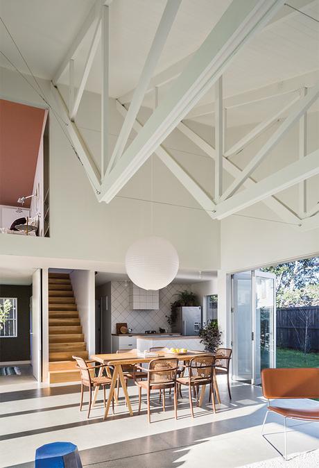 New Zealand great room with exposed trusses, paper lamp, and dining table