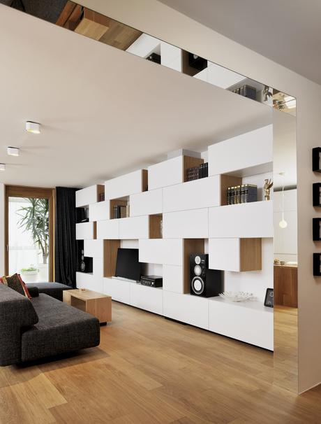 modern living room with built-in shelving and gray sofa and mirror