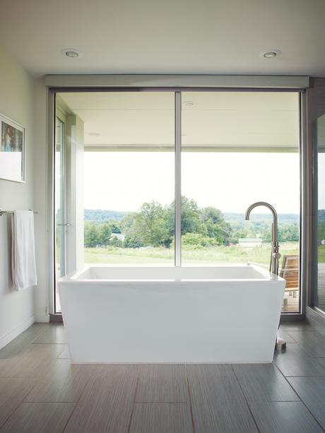 Modern master bedroom with freestanding acrylic bathtub 