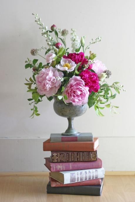 Floral Arrangement of Pink Peonies In Concrete Urn On a Stack of Vintage Books