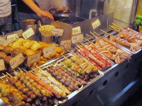 A street vendor sells food at a Taipei market. A very cheap way to eat in Asia. Choices often include chicken hearts, pork belly, chicken feet and dumplings.