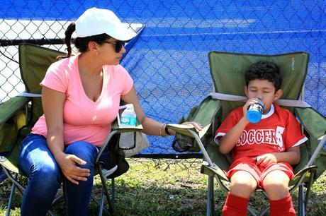 A soccer moms ultimate sideline kit should include quad chairs, a cooler full of goodies like a bowl of fruit, a first aid kit and of course, an extra soccer ball to keep handy for warm-ups and bored siblings!