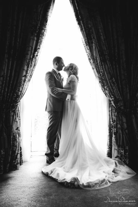 bride-and-greoom-posed-by-window-black-and-white