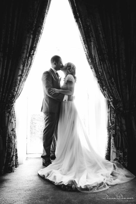 BW Bride and groom kiss at window