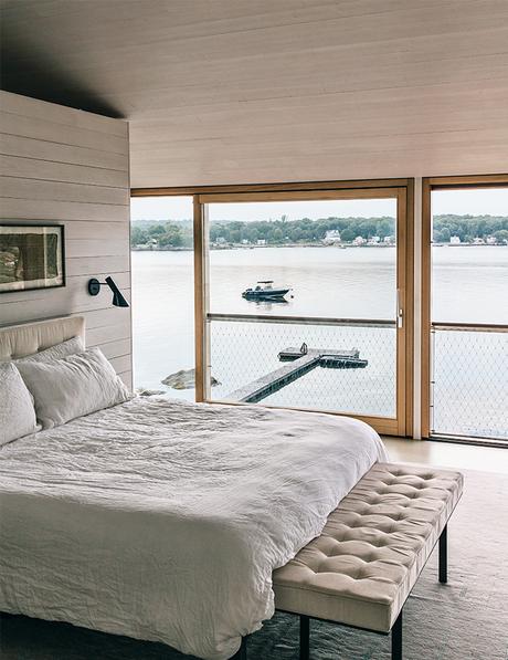 Modern Connecticut summer home renovation with Desiron bed, Arne Jacobson sconces, and Bayerworld windows and doors in the master bedroom